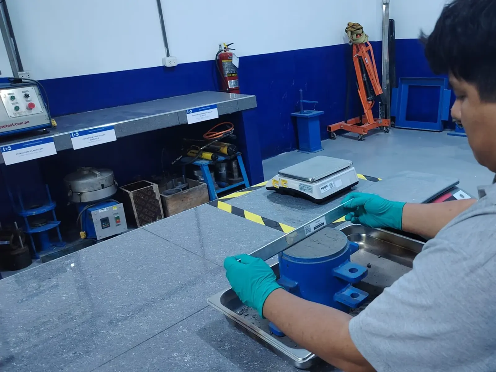 Técnico pesando una muestra en balanza de precisión dentro del laboratorio.